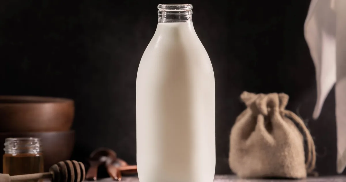 Butelka mleka na rustykalnym blacie w ciemnym wnętrzu